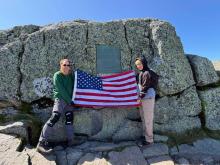 Hiram and I with flag by the first ascent plaque